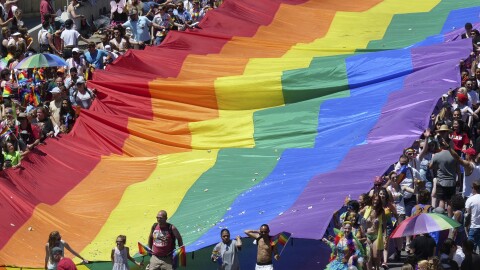 Marchers raise a rainbow flag during the 2018 Pride parade in Salt Lake City. Late Tuesday, state regulators implemented a ban on "conversion therapy" aimed at changing the sexual orientation or gender identity of LGBTQ young people.