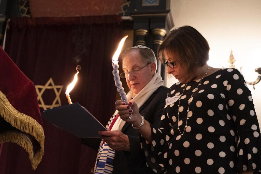 B'nai Sholom President Michael Bukstein and Joni Reisler Abramowitz light the ceremonial havdalah candles during a deconsecration ceremony at the temple on May 18, 2019.