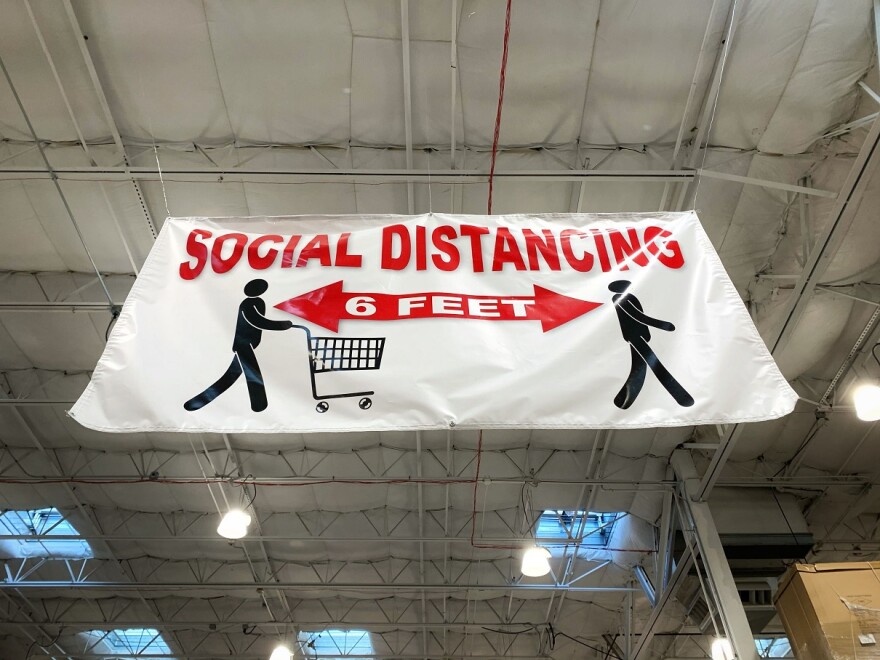 A banner in a Colchester store cautions shoppers about keeping social distance.