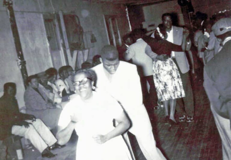 Black and white photo of a group of people dancing 