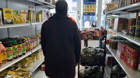 Maria walks the aisles of her market that are empty of customers.