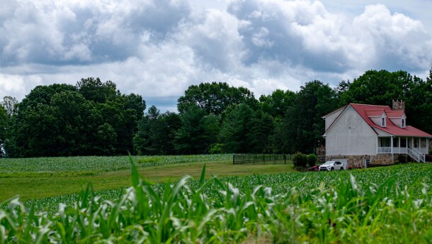 rural farmland with a house with a red roof on the right
