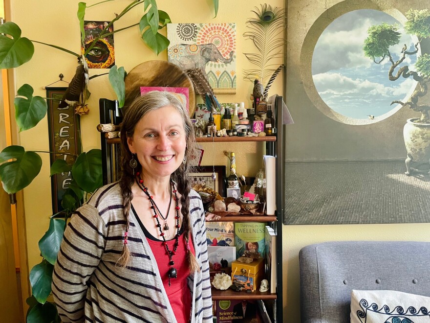 Woman standing in room with shelf and chair in the background