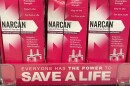 Pink-and-white boxes of Narcan are shown, with a pink ad beneath that says 'Everyone has the power to save a life.' A store price tag reads $44.99.