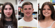 Three high school students look toward the camera while smiling,