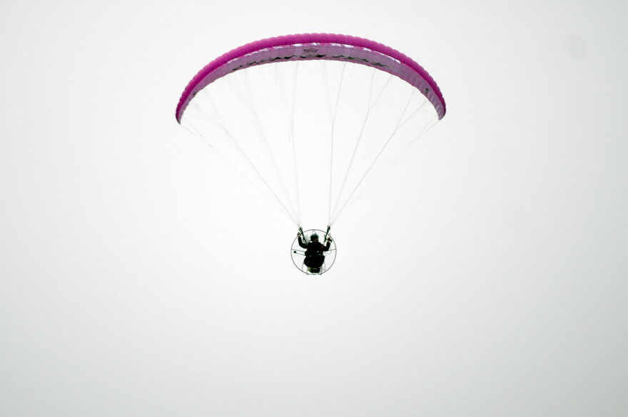 Jake Hutzler flies his paramotor in a clear sky.