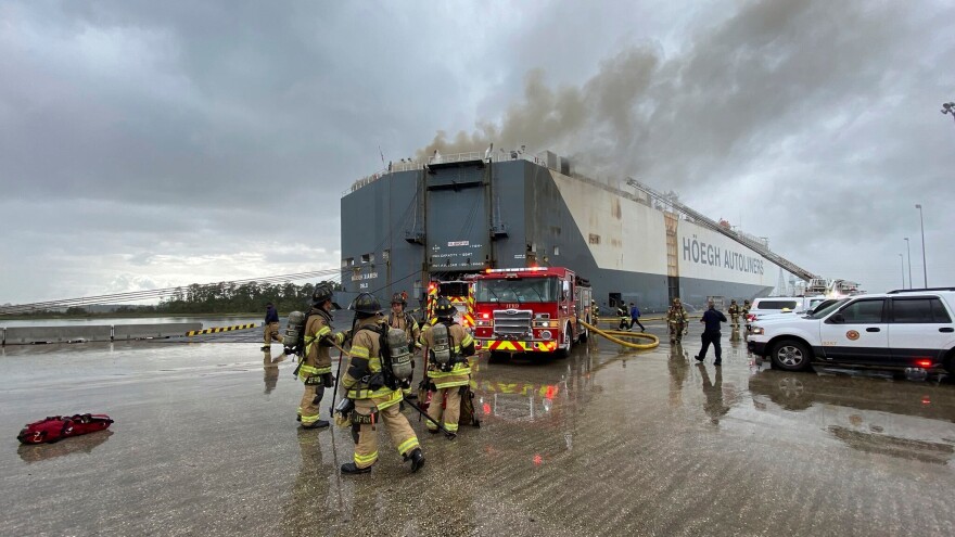 This photo provided by The Jacksonville Fire and Rescue Department shows firefighters responding to a fire after an explosion aboard a ship on June 4, 2020, in Jacksonville.