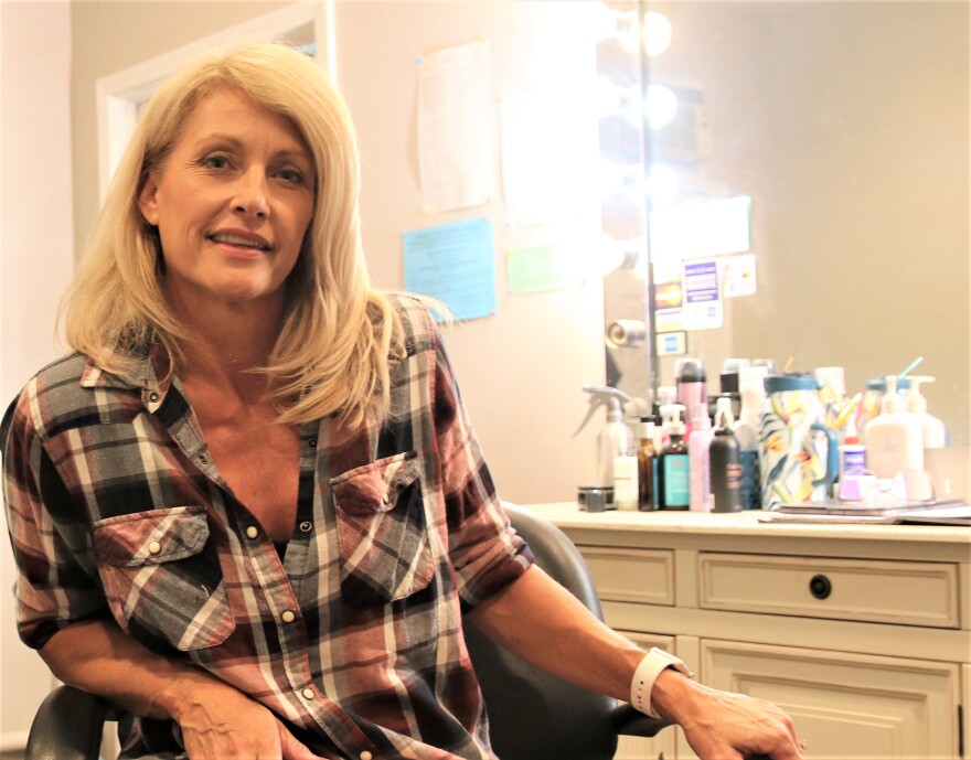 Woman sitting in a hairdresser's chair.