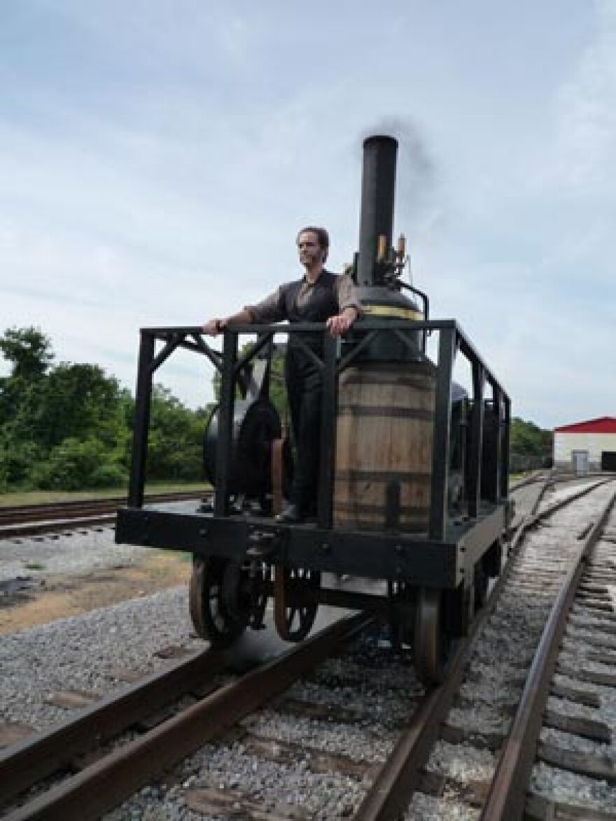 Actor Scott Klavan (who plays Peter Cooper) on a scale model of the Tom Thumb in Baltimore