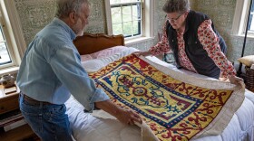 John Shambroom and Loose Ends volunteer Jan Rohwetter examine the rug Shambroom's wife, Donna Savastio, couldn't finish due to symptoms of Alzheimer's.