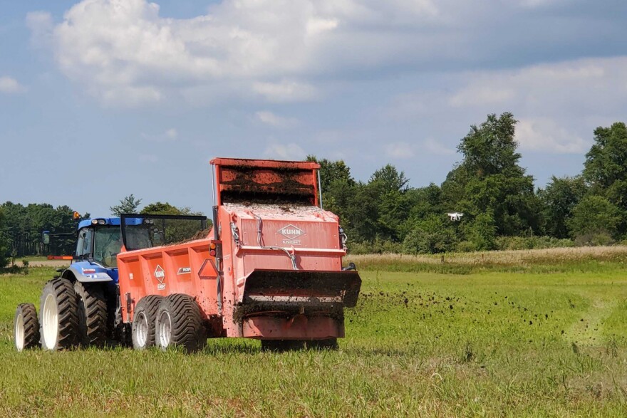 Companies demonstrate their solid manure spreaders out in the field to expo attendees.