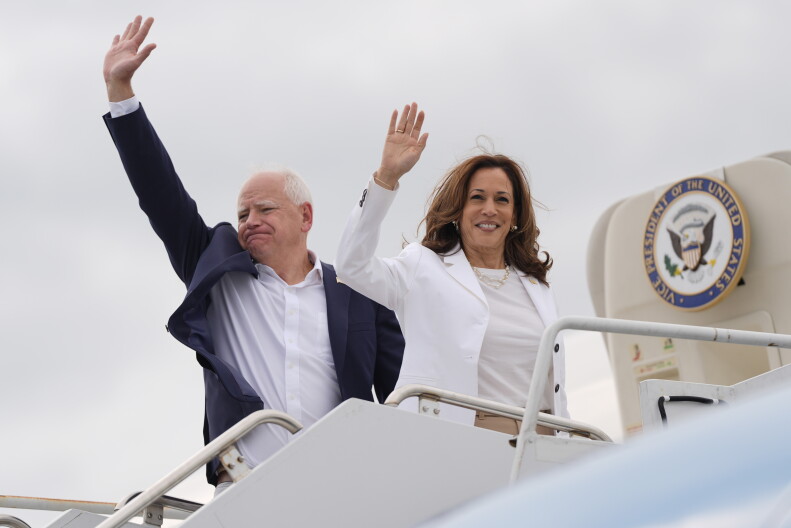 Democratic presidential nominee Vice President Kamala Harris and her running mate Minnesota Gov. Tim Walz wave as they board Air Force Two.