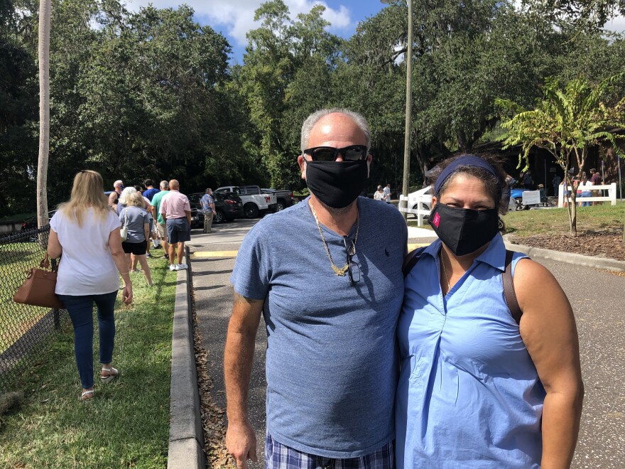Herb and Maria Valdez wearing masks standing outside the Riverview Branch Library to vote early.