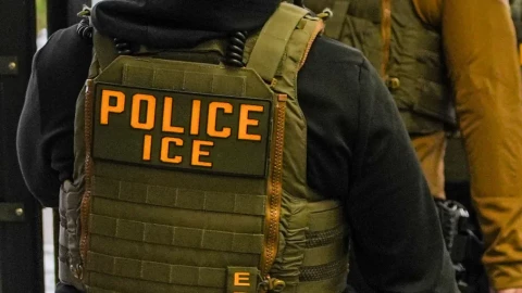 An ICE agent in a tactical vest.