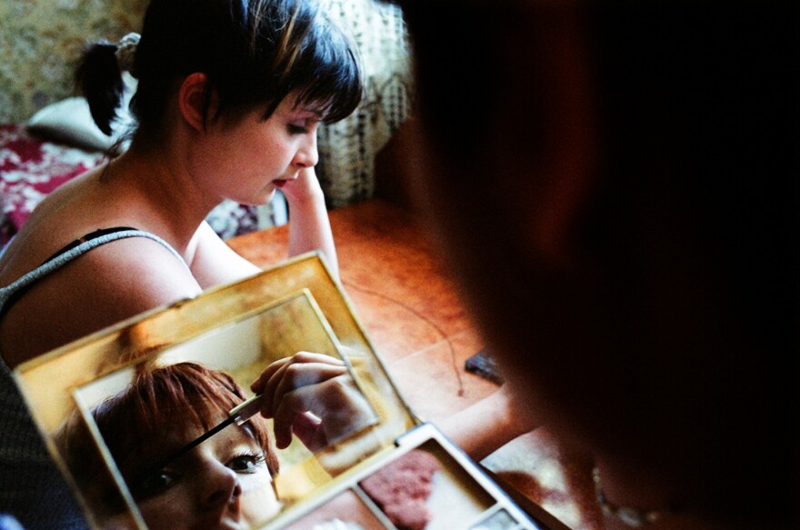 Two Moldovan women apply makeup before going out with friends.