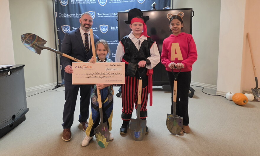 Dean Pettinato, director of the Scranton School for Deaf & Hard-of-Hearing Children, and some of the school's students pose for a photo during an event to mark the start of renovations for a wellness center.