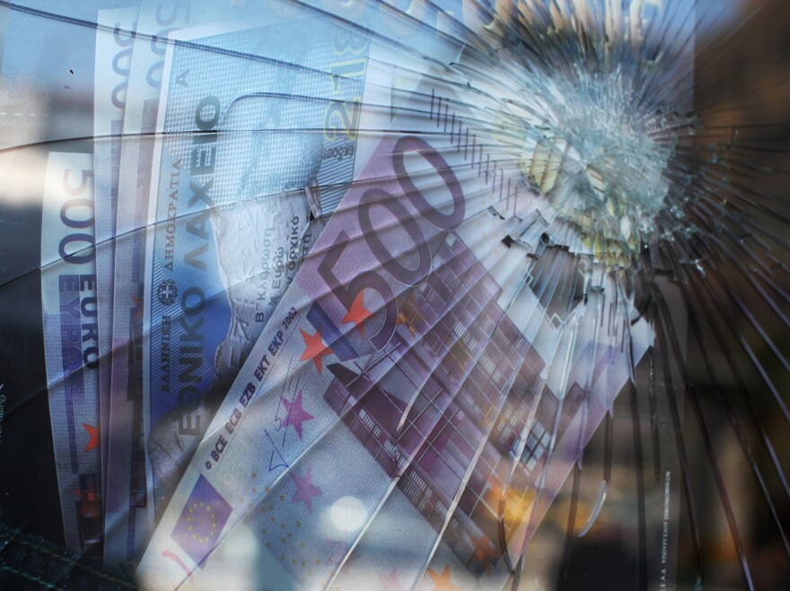 A money transfer shop sports a broken window in front of a poster of euro banknotes on June 12 in Athens, Greece. The Greek electorate will go to the polls in a re-run of the general election on June 17 after no combination of political parties were able to form a coalition government. That vote could determine whether Greece retains the Euro as its currency.
