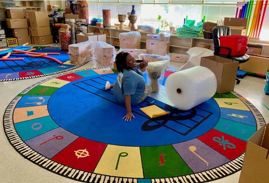 Park Road music teacher McKenzie Coleman wraps musical instruments for the move to Sedgefield Montessori School.