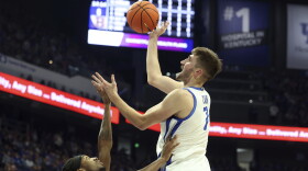 Kentucky's Andrew Carr, right, shoots while defended by Brown's Lyndel Erold, left, during the first half of an NCAA college basketball game in Lexington, Ky., Tuesday, Dec. 31, 2024. (AP Photo/James Crisp)