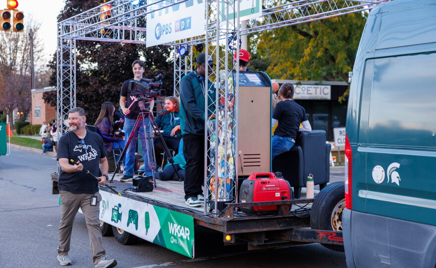 WKAR Broadcast Engineering Manager Kenneth Merley walks alongside the joint WKAR and College of Communication Arts and Sciences float in the Michigan State University Homecoming Parade in East Lansing, Mich., on Oct. 9, 2026.