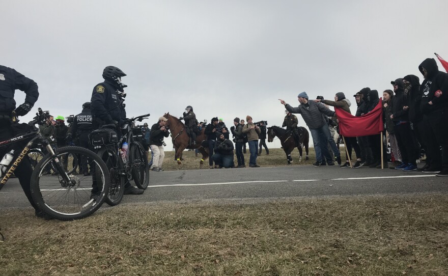 Protestors form a human wall to face wall of police.