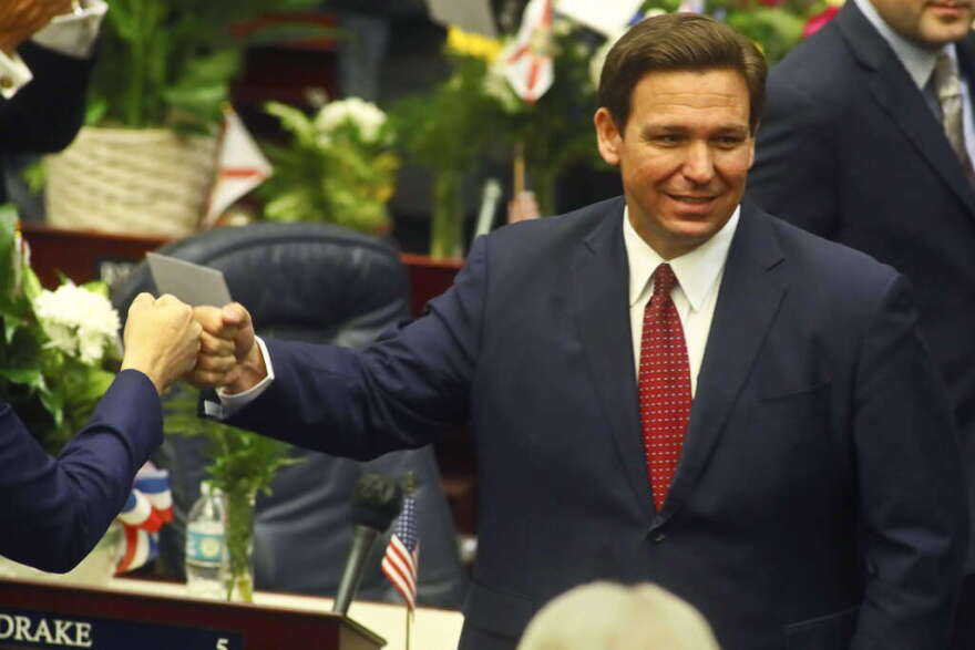 FILE - In this Tuesday, March 1, 2021 file photo, Florida Gov. Ron DeSantis fist bumps with legislators as he enters the House of Representatives prior to his State of the State address at the Capitol in Tallahassee, Fla. Democrats hope to make deeper strides in changing their fortunes in a state that has become friendlier place for Republicans. The state's only Democrat in statewide office, Agriculture Commissioner Nikki Fried is contemplating a challenge to Republican Gov. DeSantis.  (AP Photo/Phil Sears, File)