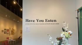 A white wall is in frame with the words 'Have you Eaten' in black type on it. Underneath reads 'an Asian American, Native Hawaiin, and Pacific Islander exhibit. 