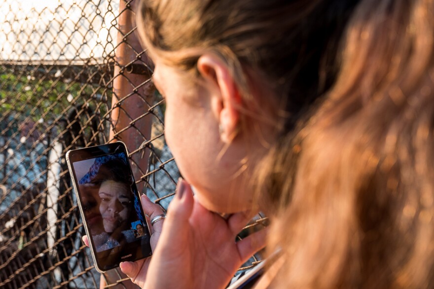 Laura and Medel chat via video call.