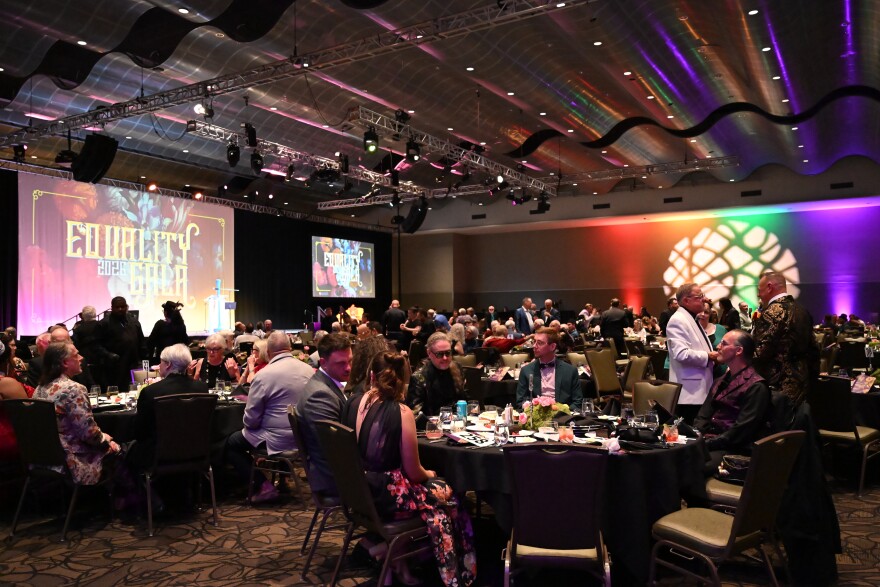 Tulsa community members sit at their tables within the Arvest Convention Center as they await their dinner.