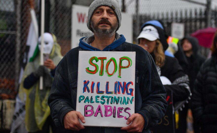 A protester carries a sign outside the Scranton Army Ammunition Plant during the Rally for Palestine.