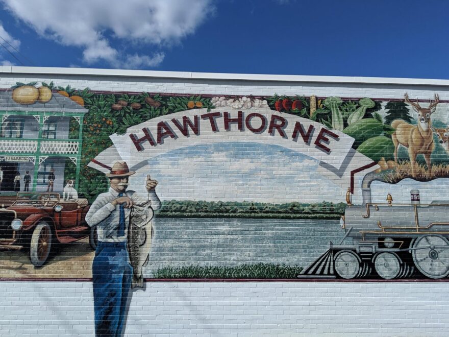 A mural on the side of the town hall representing Hawthorne’s agricultural and sporting history. (Julia Grady-Weil/WUFT News)