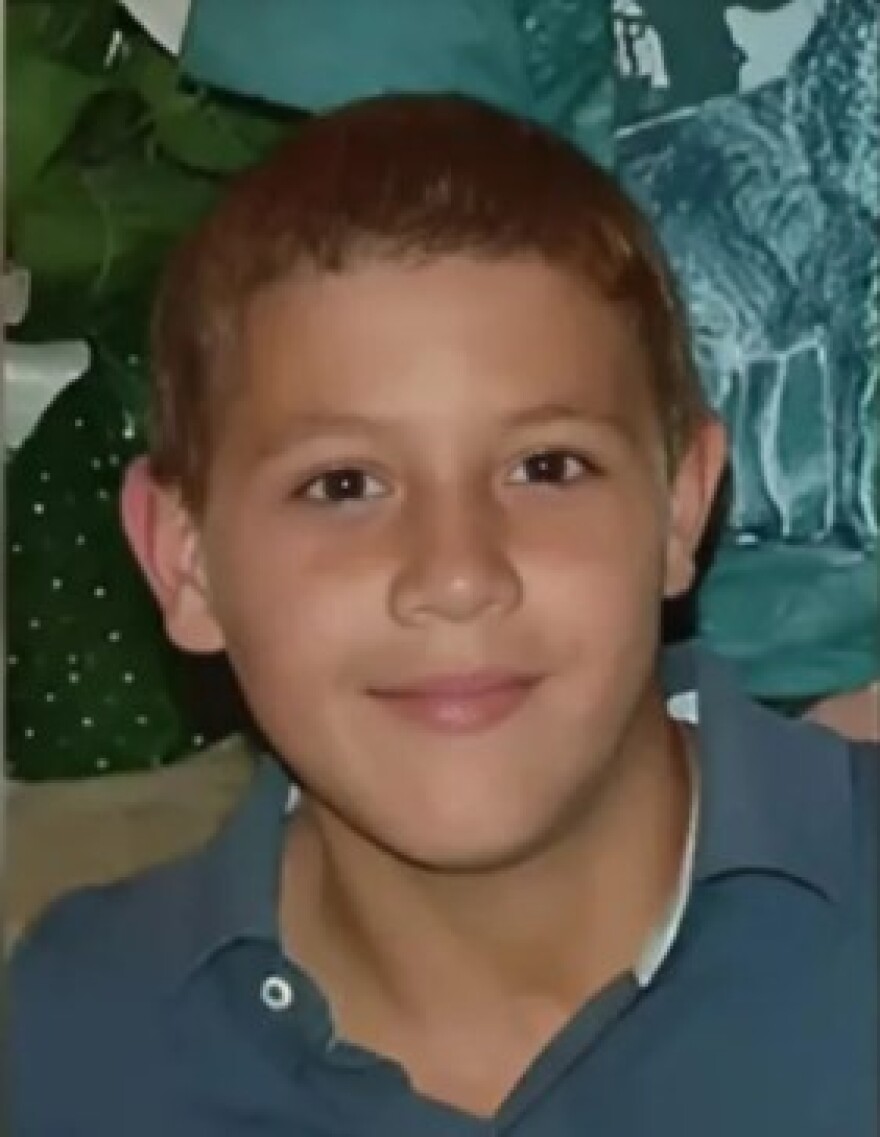 Teenage boy with a green shirt smiling into the camera