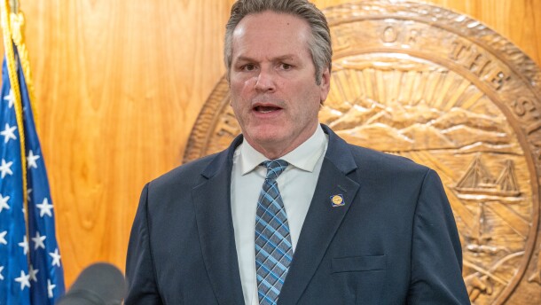Man speaking in front of state seal