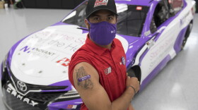 NASCAR driver Bubba Wallace shows off his bandage covering where he received his COVID-19 vaccination