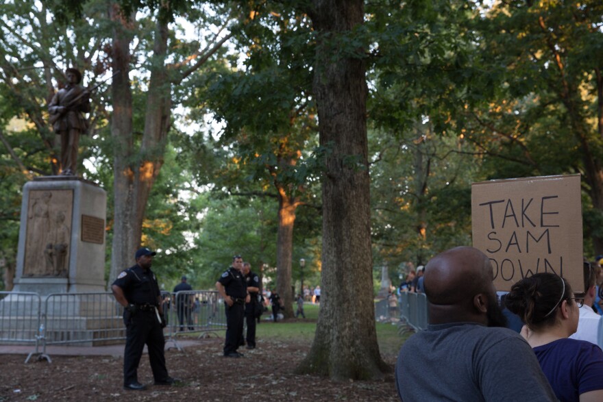 Police inside the barricade around the Silent Sam monument watch protests for the statue’s removal at the University of North Carolina at Chapel Hill. Protestors for and against the statue’s removal attended rallies near the monument on Tuesday, August 22