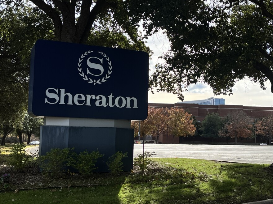 The Sheraton Arlington Hotel sign stands in the entertainment district. Loews Arlington Hotel stands in the background.