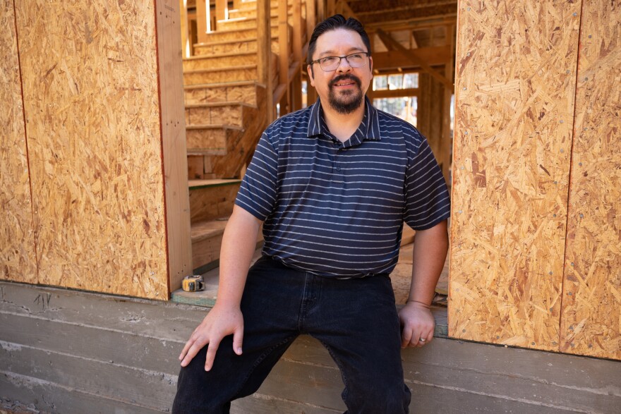 Victor Diaz sits on the foundation of the new home he is building to replace his home lost in the Caldor Fire, Thursday, August 4, 2022. Andrew Nixon / CapRadio