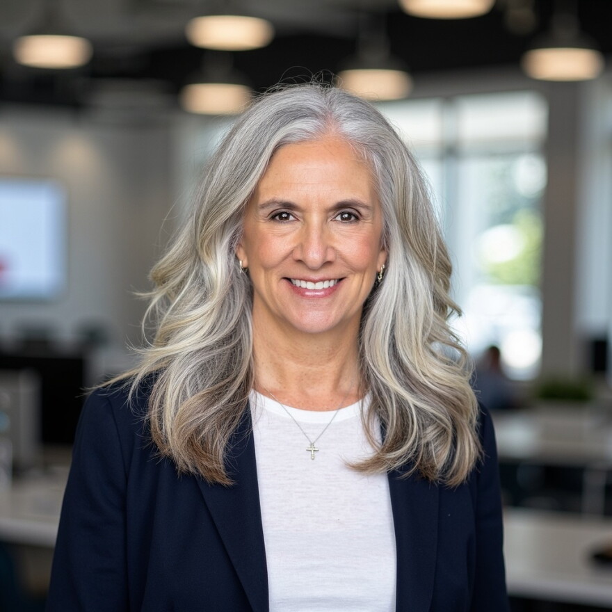 Professional portrait of a woman in a navy blue blazer.