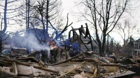 A fire still burns in a home destroyed by the Marshall Wildfire in Louisville, Colo., on Dec. 31, 2021. (Jack Dempsey/AP)