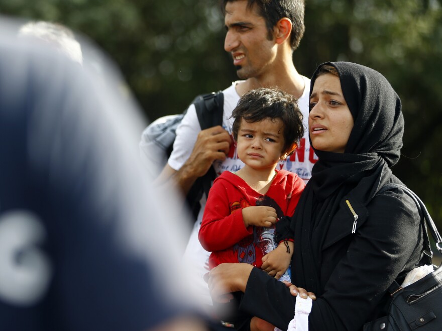 A migrant family stands at the border in Roszke, Hungary, after Hungarian police officers closed access between Serbia and Hungary on Monday.