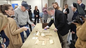 CHI St. Vincent Market Dir. of Mission Michael Millard displays contents of 97-year-old time capsule retrieved from the cornerstone of St. Joseph Hospital
