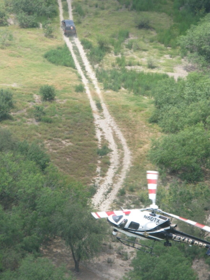When a group of suspected illegal crossers spots DPS helicopters hovering over the Rio Grande, they run and hop back into this truck which speeds away from the river near Reynosa, Mexico.
