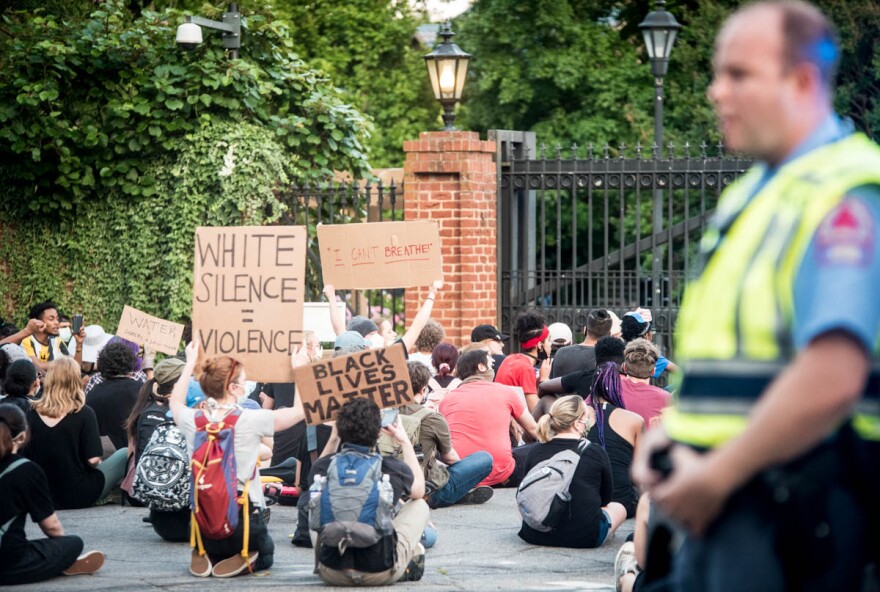 Police watch as a crowd gathers outside the governor's mansion in downtown Raleigh on Tuesday night to protest the death of George Floyd and violence against black Americans.