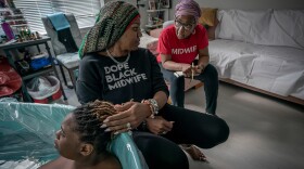 Doula Mayasa Telfair, center, updates midwife Marsha Jackson on Tonithia Reid’s labor. Only when Telfair was fairly sure Reid was ready to give birth did she call in Jackson. Reid delivered soon after the midwife arrived.