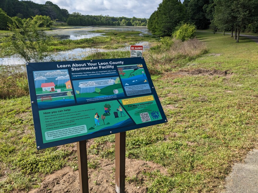 An informational sign about Lake Henrietta on the water body's bank