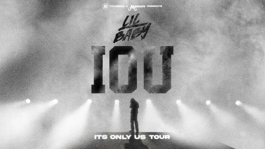 A promotional photo shows a man's silhouette on stage with smoke surrounding him and a line of stage lights behind him.