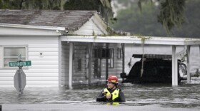 A first responder with Orange County Fire Rescue makes her way through floodwaters looking for residents of a neighborhood needing help in the aftermath of Hurricane Ian, Thursday, Sept. 29, 2022, in Orlando, Fla.