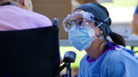 Jennifer Romero, a registered nurse with the Florida Department of Health, explains the process of the specimen collection to a nursing home resident in Northeast Florida, May 1, 2020. (Photo by Sgt. Michael Baltz, “Florida National Guard,” CC BY 2.0)