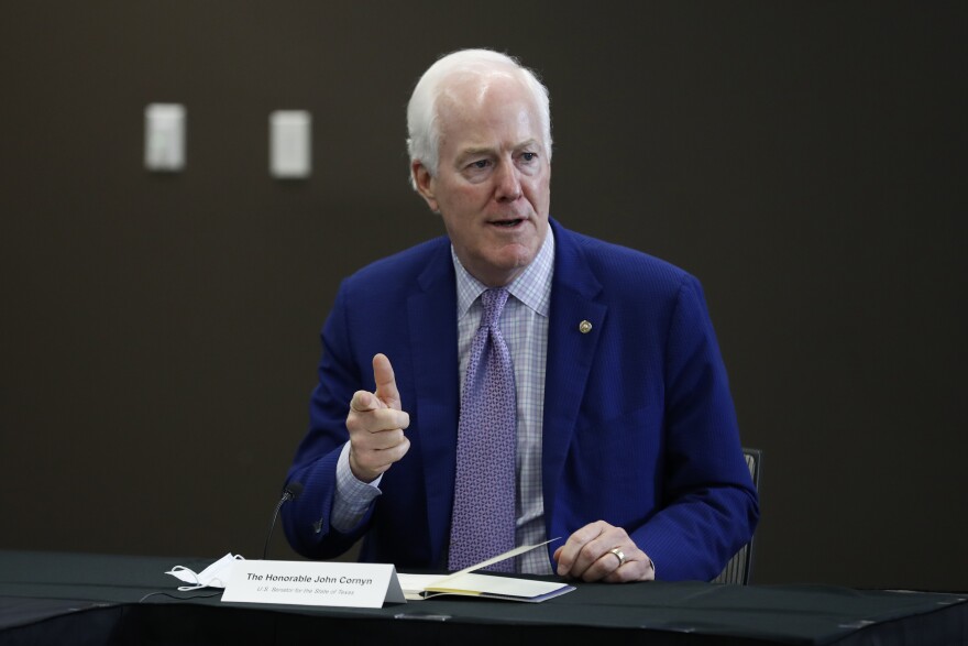 Photo of John Cornyn speaking while seated at press conference.