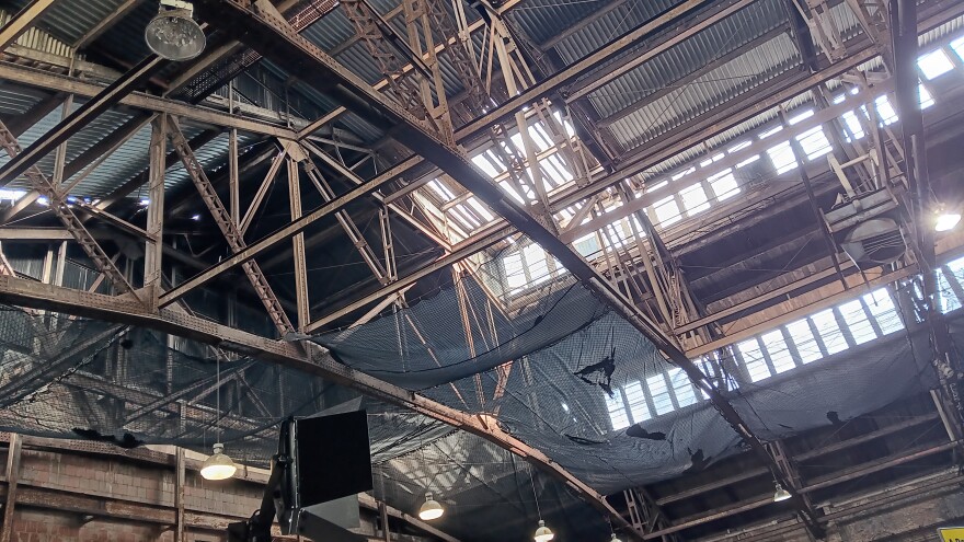 A view inside the Broadway Barn shows broken windows, open air atop the ceiling, and netting to catch falling debris.